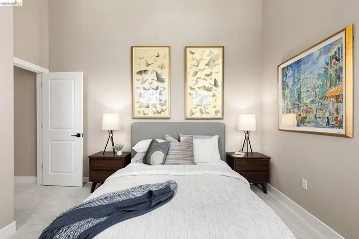 Carpeted bedroom featuring baseboards and a high ceiling