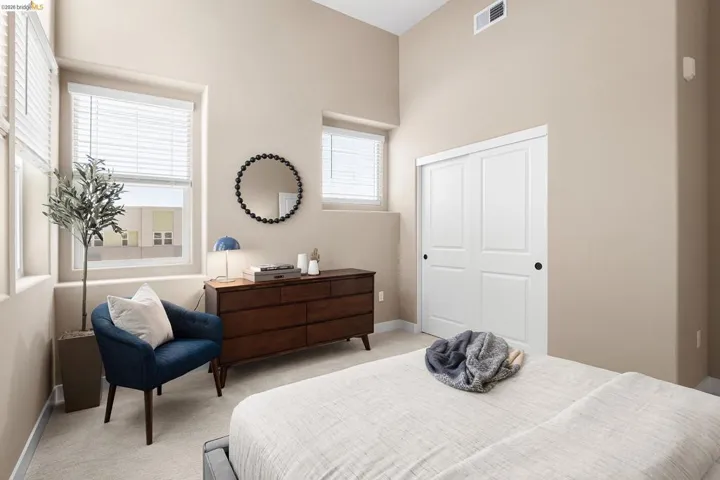 Bedroom with light carpet, a closet, and a high ceiling