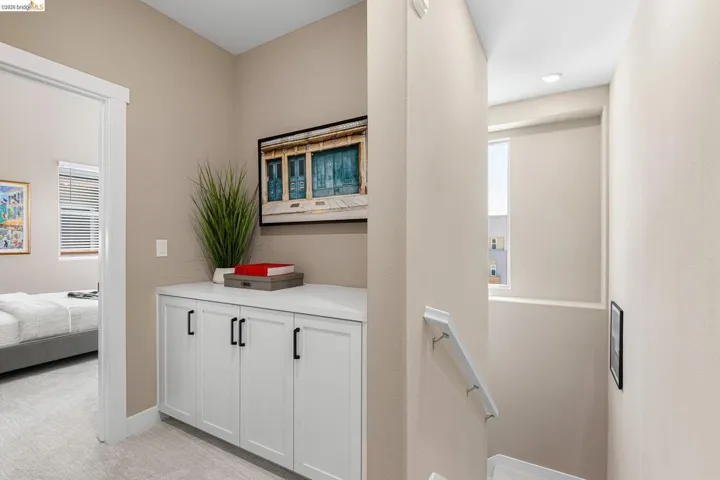 Corridor with light colored carpet and an upstairs landing