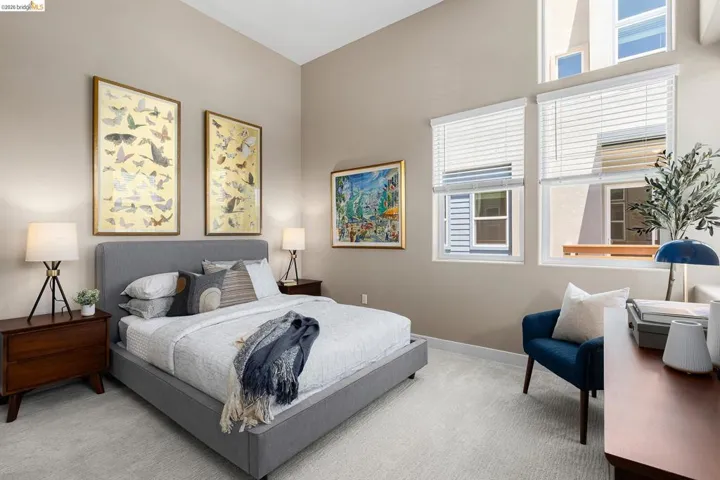 Carpeted bedroom featuring baseboards and a high ceiling