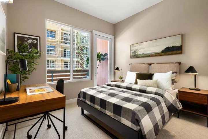 Carpeted bedroom featuring an office area and baseboards