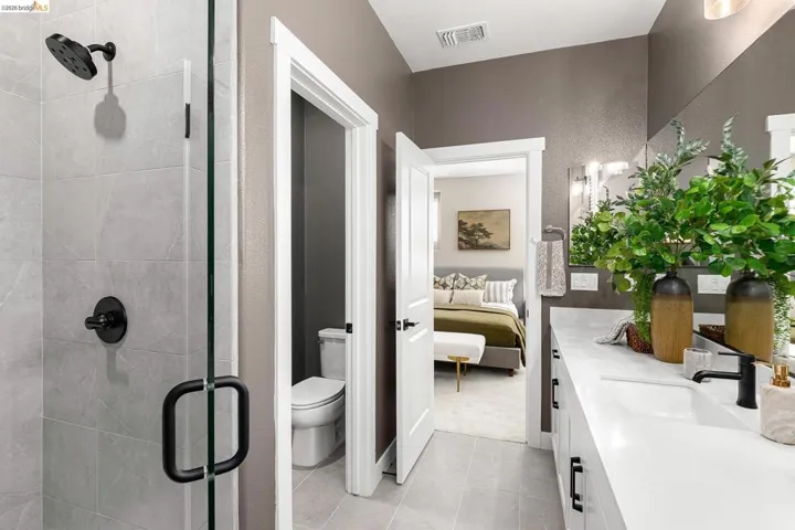 Ensuite bathroom featuring vanity, a stall shower, and tile patterned flooring