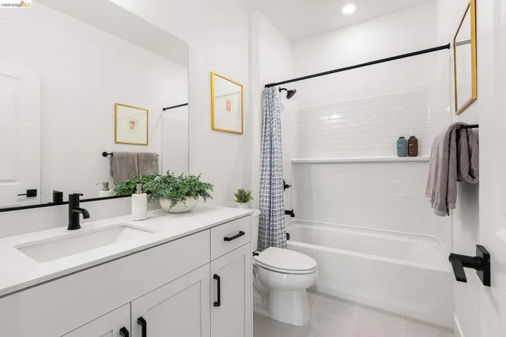 Full bathroom with vanity, shower / bathtub combination with curtain, tile patterned floors, and recessed lighting