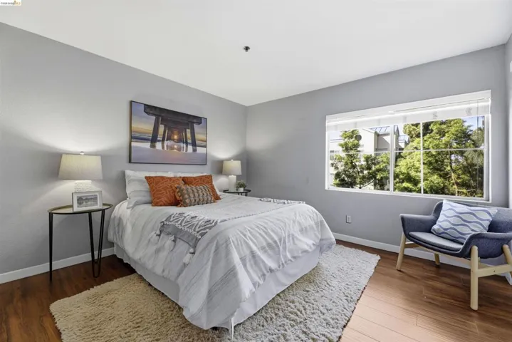 Bedroom with dark wood-style flooring and baseboards