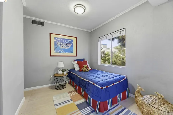 Bedroom with crown molding, a textured ceiling, and a textured wall