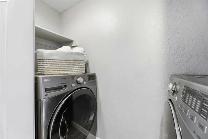 Laundry area featuring washer and dryer and a textured wall