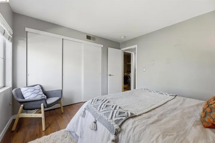 Bedroom with a closet, dark wood-type flooring, and washer / clothes dryer