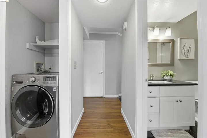 Laundry area featuring washer / dryer, dark wood-type flooring, and a textured ceiling