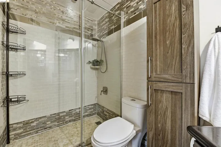 Bathroom with a shower stall and toilet