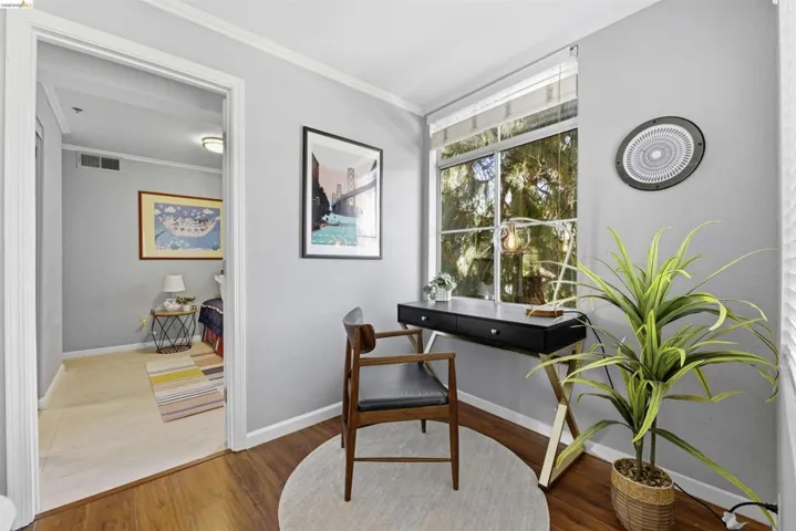 Living area featuring crown molding and wood finished floors