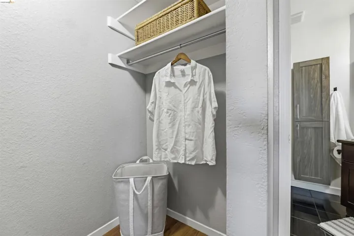 Walk in closet with dark wood finished floors