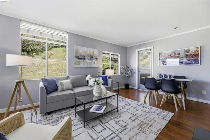 Living room featuring dark wood-style flooring and crown molding
