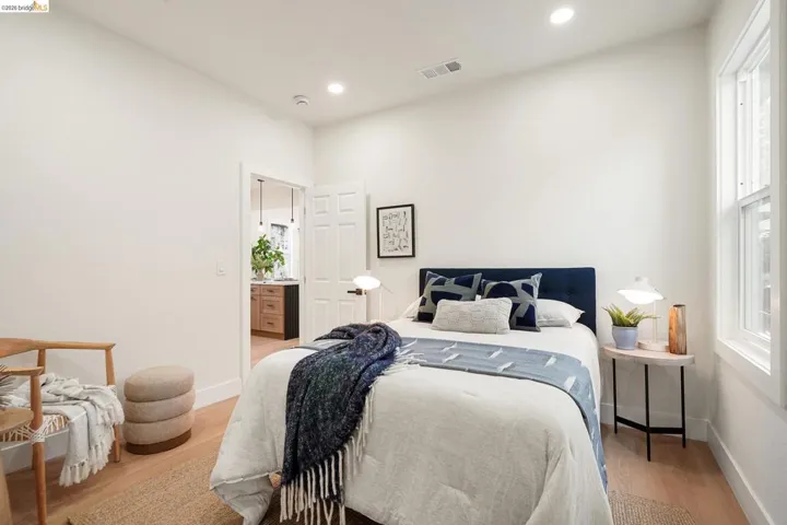 Bedroom with light wood-type flooring, multiple windows, and recessed lighting