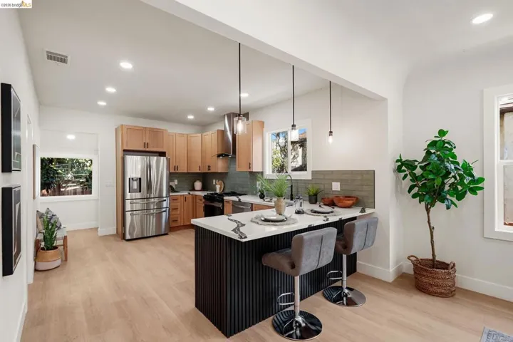 Kitchen featuring pendant lighting, stainless steel appliances, a kitchen breakfast bar, recessed lighting, and a peninsula
