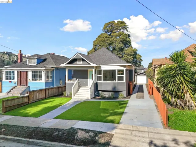 Bungalow-style home with an outdoor structure, roof with shingles, and covered porch