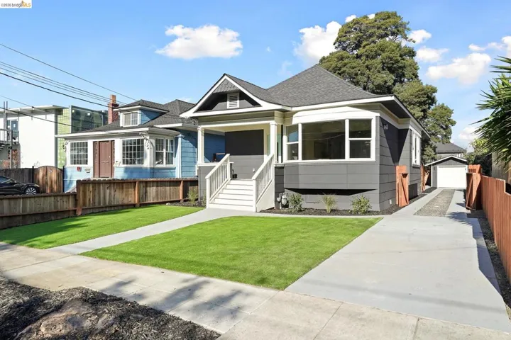 Bungalow-style house with an outbuilding, roof with shingles, covered porch, and a detached garage