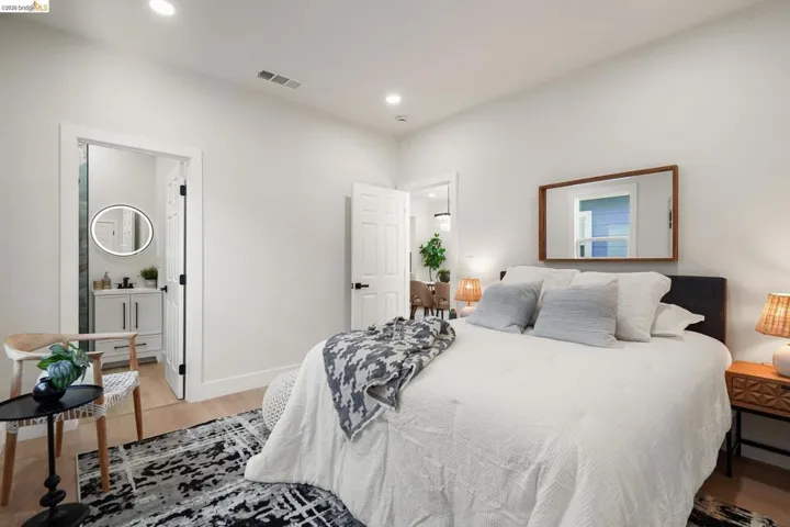 Bedroom featuring light wood-style floors, recessed lighting, and ensuite bath