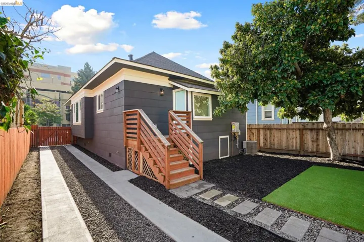 Rear view of house with a fenced backyard and a shingled roof