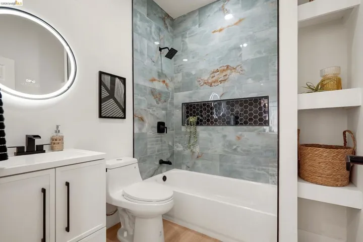 Bathroom featuring vanity, shower / washtub combination, and light wood-style flooring