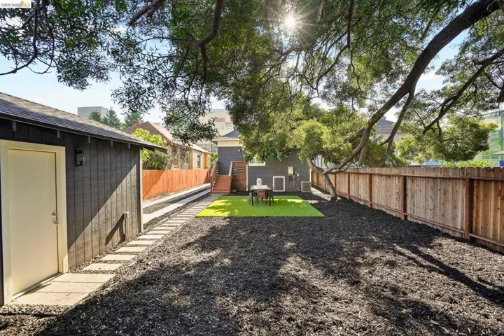 Fenced backyard featuring an outbuilding and a patio area