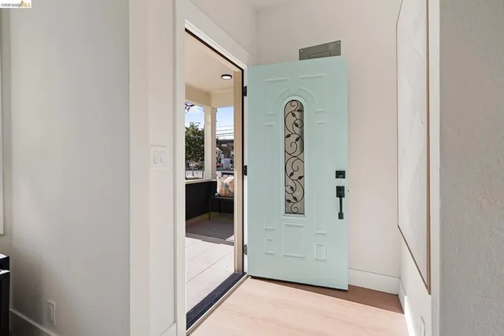 Foyer with light wood finished floors and a textured wall