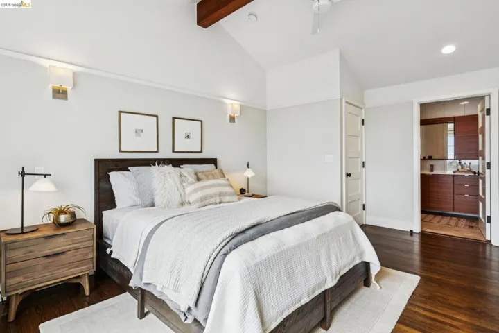 Bedroom with lofted ceiling with beams, dark wood-type flooring, a ceiling fan, recessed lighting, and ensuite bathroom
