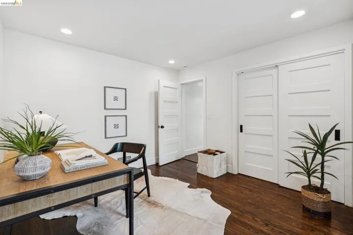 Home office with dark wood finished floors and recessed lighting