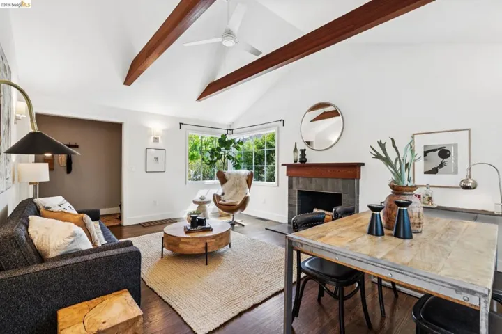 Living area with wood finished floors, a tile fireplace, and vaulted ceiling