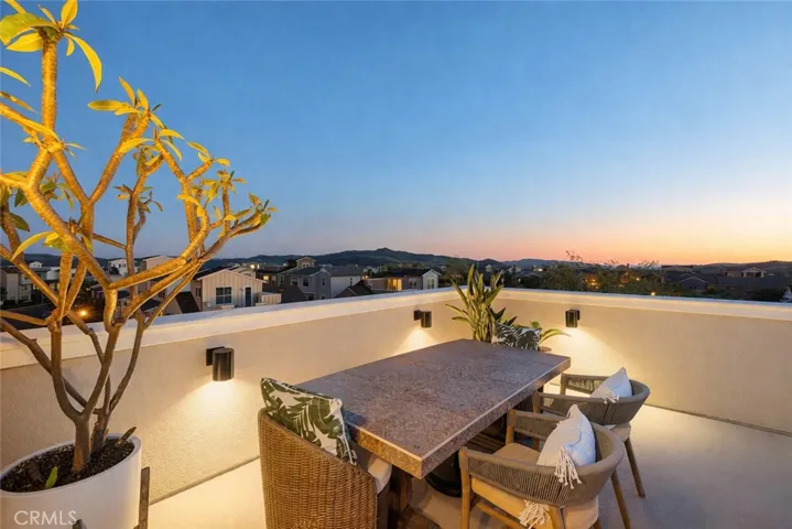 Rooftop dining deck framed by sunset skies and panoramic views.