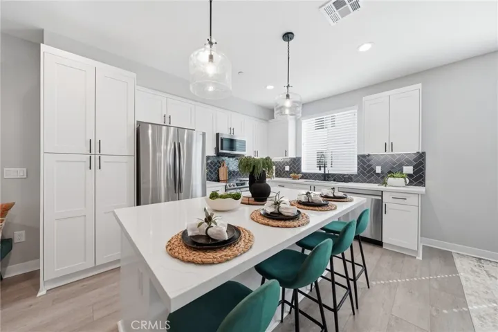 Large Open Kitchen with quartz countertops, self close cabinets/drawers, pantry, stainless steel appliances.