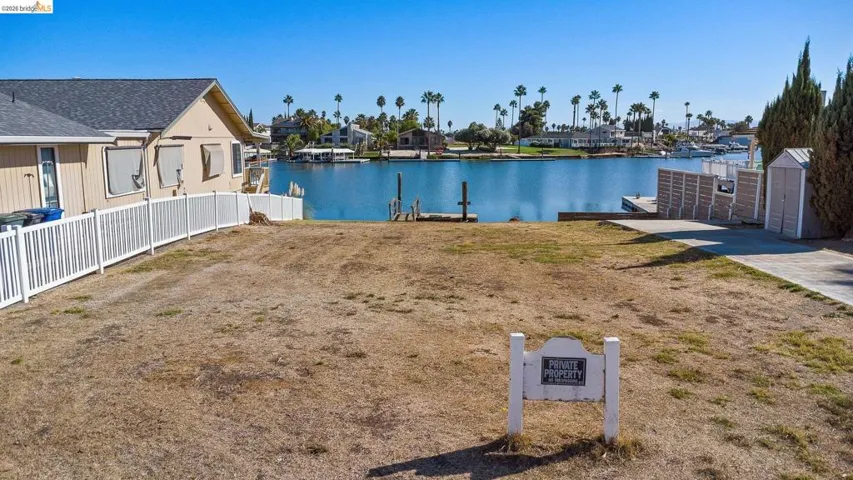 Water view featuring nearby suburban area, a boat ramp, and a boat dock