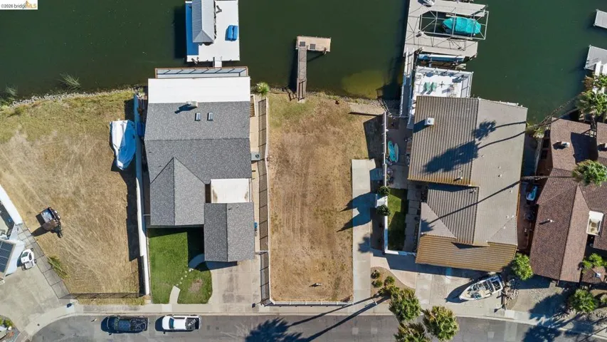 Aerial view of property's location featuring a nearby body of water and nearby suburban area
