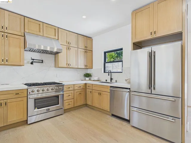 Kitchen featuring stainless steel appliances, light wood-type flooring, light wood finish cabinetry, backsplash, and recessed lighting
