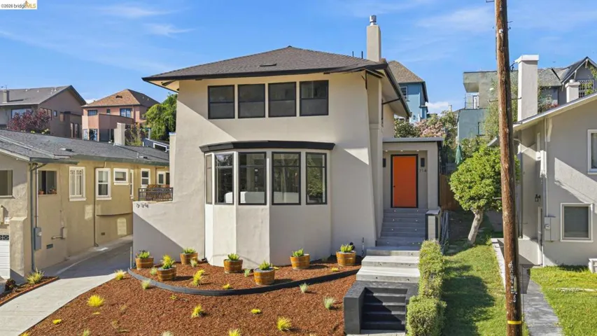 View of front of home featuring stucco siding, a residential view, and a chimney