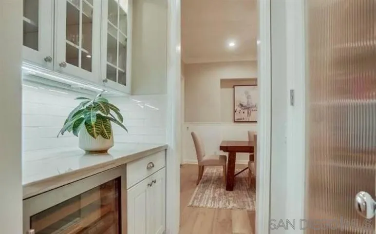pantry, wine fridge/bar area between kitchen and dining room
