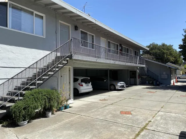 View of front facade with stairs and stucco siding