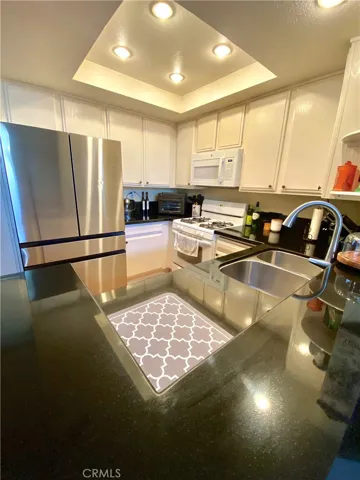 The kitchen boasts black marble countertops, recessed lighting and plenty of space for cooking and entertaining.