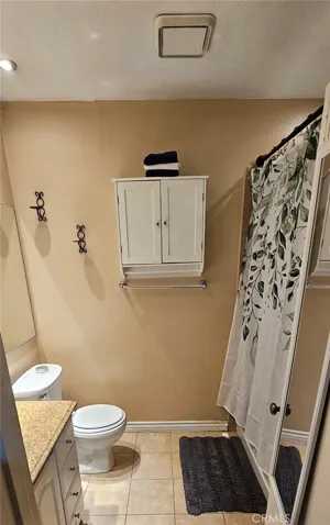 Spacious bathroom with a calming colour scheme and nice hanging cabinet.