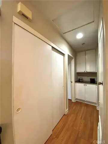 View from the hallway and extra big closet from the living room. Across from the closet is furnace door.