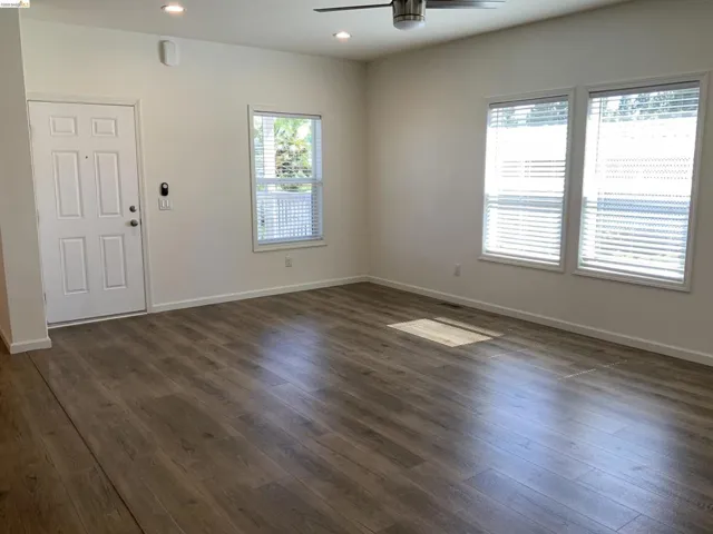 Spare room with dark wood-type flooring, a ceiling fan, and recessed lighting