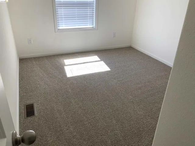 Carpeted empty room featuring baseboards