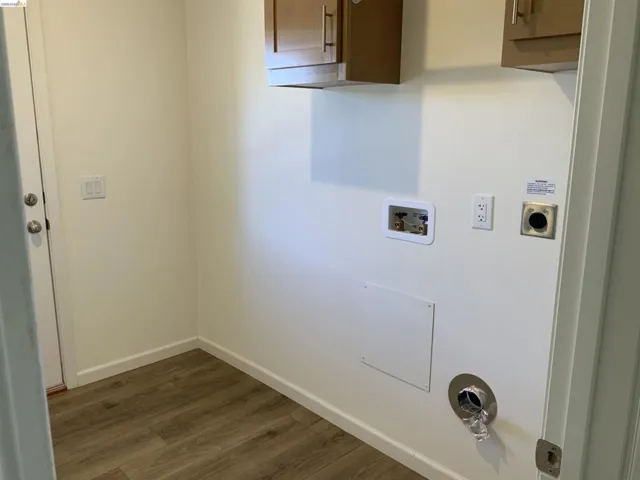 Laundry area featuring dark wood-style floors, washer hookup, and electric dryer hookup