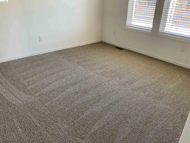 Carpeted empty room with baseboards