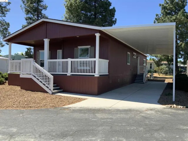Manufactured / mobile home featuring a porch, an attached carport, driveway, and crawl space