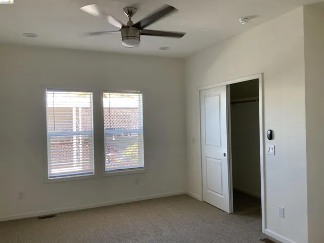 Unfurnished bedroom featuring light carpet, a closet, and ceiling fan