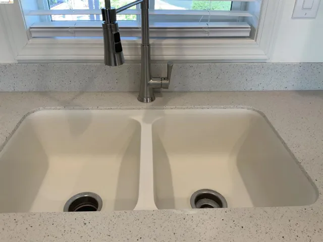 Kitchen view of light stone countertops and a sink