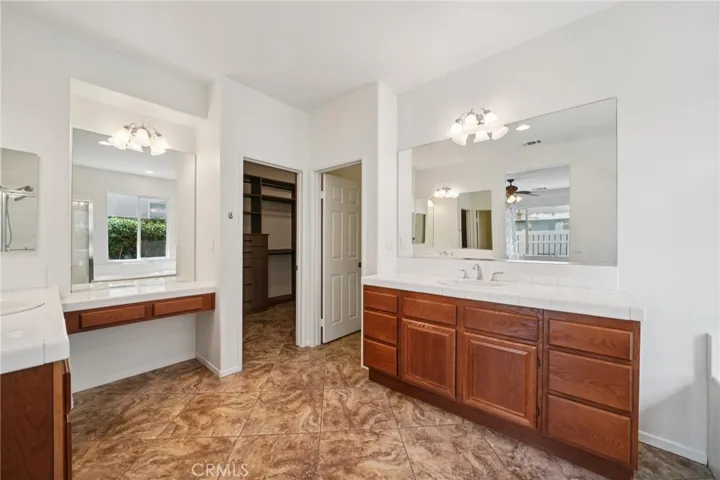 Primary bathroom with dual vanities and ample storage