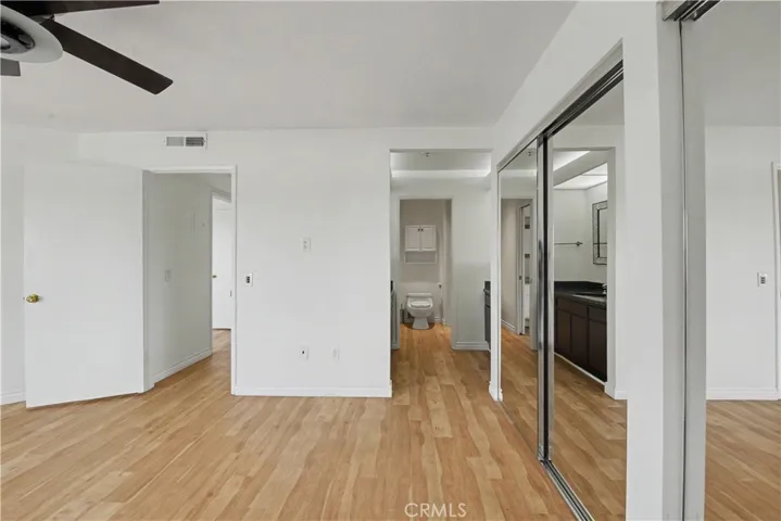Mirrored closets feature custom California Closet storage.