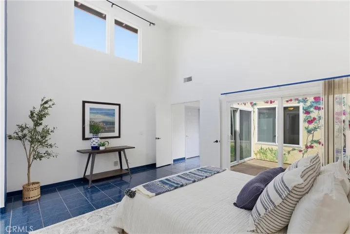 Primary bedroom with vaulted ceilings and natural light
