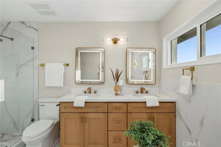 The primary bathroom boasts a spa-like retreat with large-format marble hexagon tile